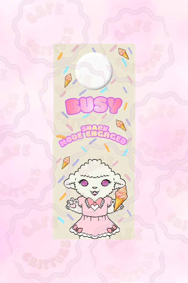 3.5 x 8.5 inch “Busy Snacking” door hang tag with a cutout hole at the top, pastel striped background, and small snack illustrations. The Cafe Critterz design features the words “Busy” and “Snack Loading” above Sleepy Sweet, a lamb character in a pink outfit holding a snack, for a cute cozy door sign look.