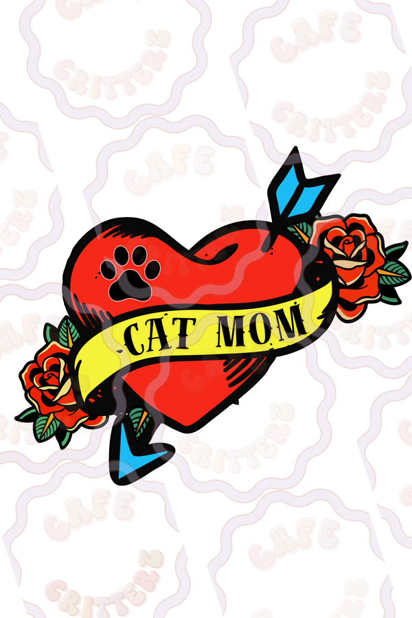 Retro tattoo-inspired "cat mom" sticker featuring a bright red heart wrapped in a pale yellow banner with “Dog Mom” lettering. The playful design includes a black paw print, blue flowers, green leaves, and white bone accents for a sweet vintage feel with a cozy Café Critterz twist.