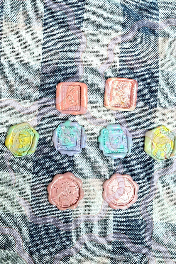Set of handmade pastel wax seals with marbled spring colors and raised floral stamp designs. The quarter-sized Cafe Critterz wax seal embellishments have a soft vintage-inspired look for junk journals, scrapbooking, happy mail, gift wrapping, and creative paper crafts.